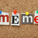 The word Meme in magazine letters pinned to a cork notice board. Meme is used to describe a piece of information or an element of culture in various media.
