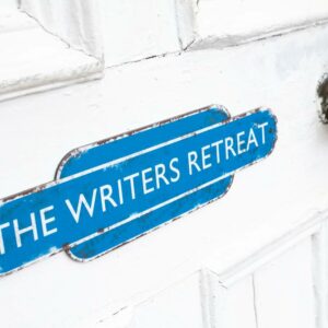 White door with a blue sign that reads, The Writers Retreat