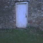 White wooden door in a stone wall