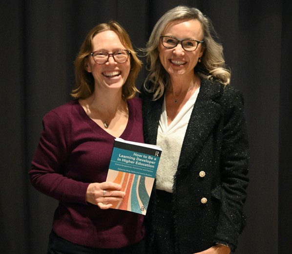 Alicja Syska and Carina Buckley hold a copy of the book "How to Be a Learning Developer in Higher Education